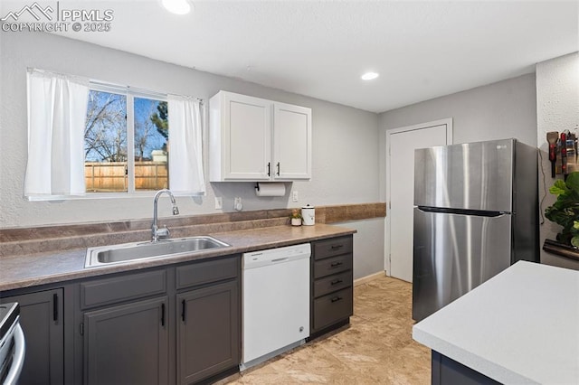 kitchen with white cabinets, sink, stainless steel fridge, white dishwasher, and gray cabinetry