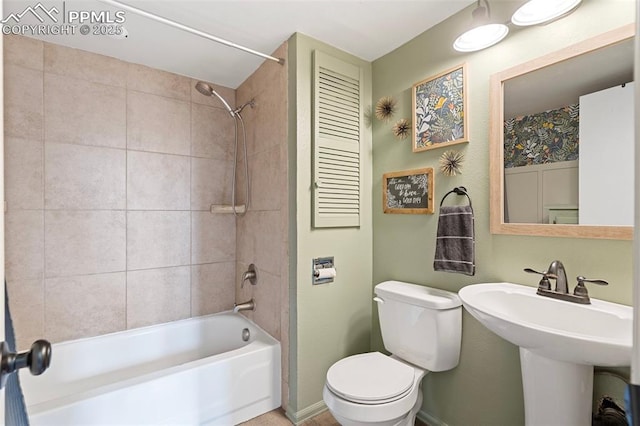 full bathroom with tiled shower / bath combo, sink, and toilet