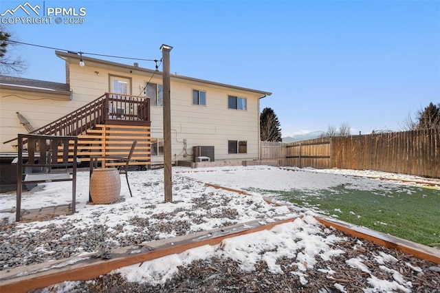 snow covered rear of property with central air condition unit