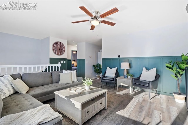 living room featuring ceiling fan and dark hardwood / wood-style floors