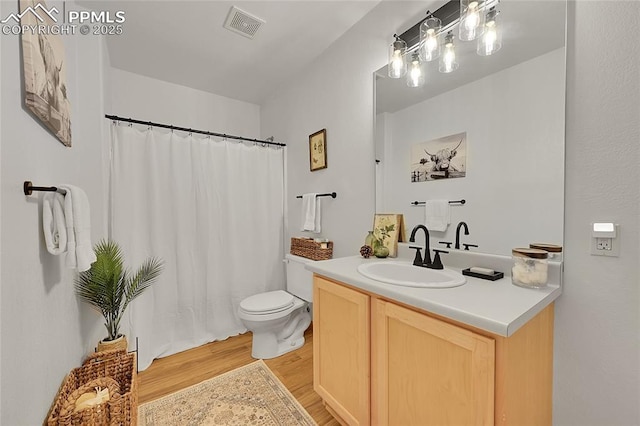 bathroom featuring hardwood / wood-style flooring, toilet, and vanity