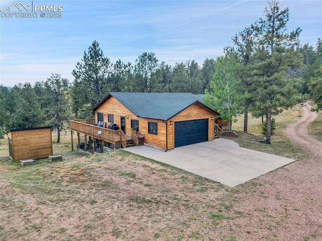 cabin with a wooden deck and a garage