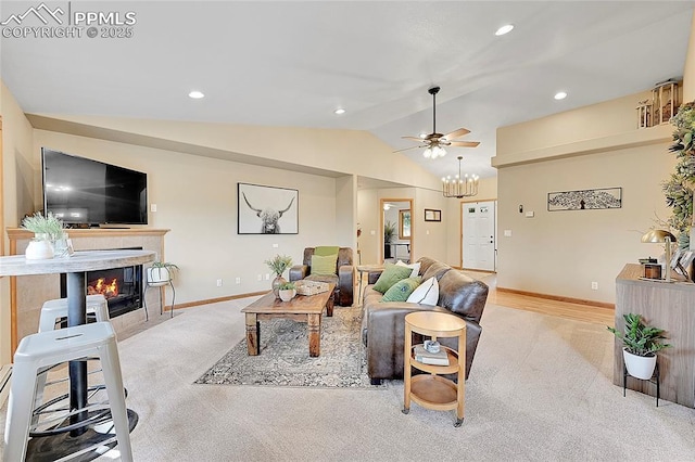 living room with light carpet, ceiling fan, lofted ceiling, and a tiled fireplace