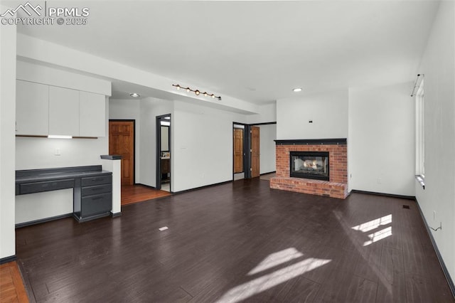 unfurnished living room with a fireplace and dark hardwood / wood-style floors