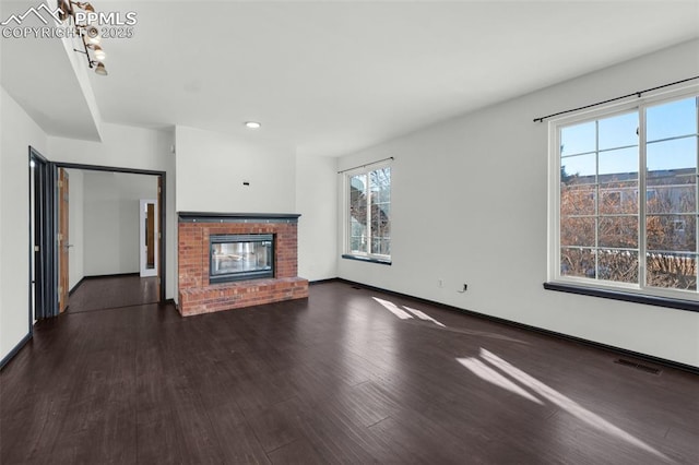 unfurnished living room with a fireplace and dark hardwood / wood-style flooring