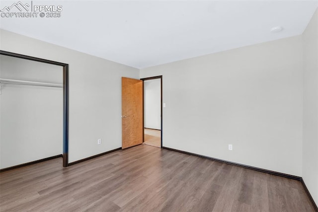 unfurnished bedroom with light hardwood / wood-style flooring and a closet