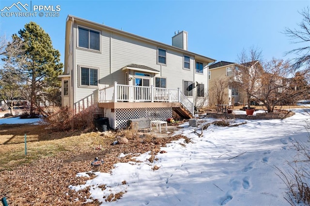 snow covered house featuring a wooden deck