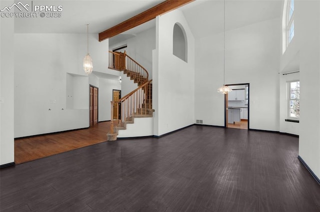 unfurnished living room with beamed ceiling, dark hardwood / wood-style floors, high vaulted ceiling, and a notable chandelier