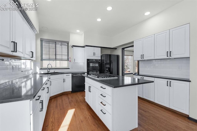 kitchen featuring white cabinetry, black appliances, and a center island