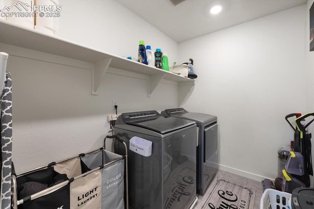 laundry room with laundry area, baseboards, and washer and dryer