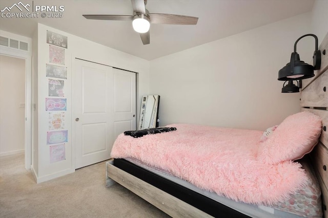 bedroom with a closet, visible vents, light carpet, ceiling fan, and baseboards