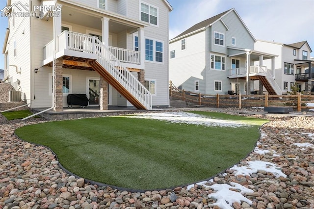 rear view of property featuring a lawn, stairway, central AC unit, a patio area, and fence