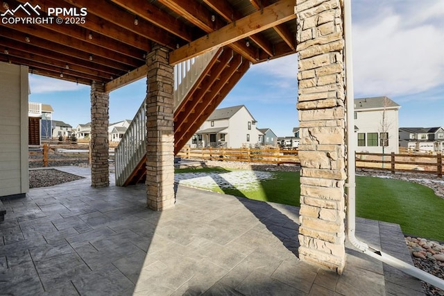 view of patio / terrace with fence and a residential view