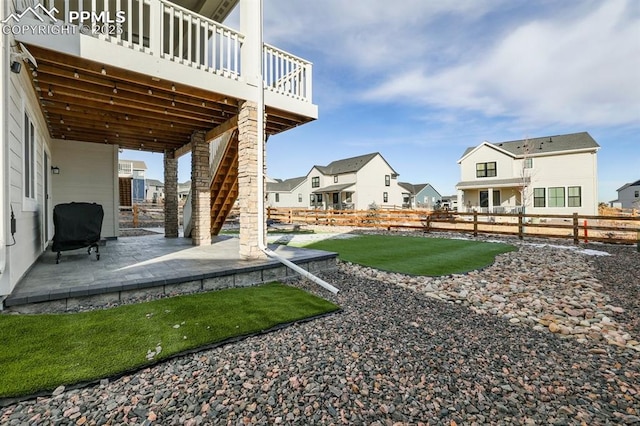 view of yard with a patio, stairway, fence, and a residential view