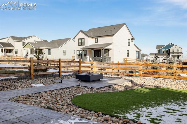 exterior space featuring a patio, an outdoor fire pit, fence, and a residential view