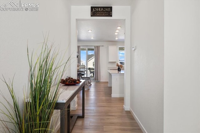 hall with light wood finished floors and baseboards