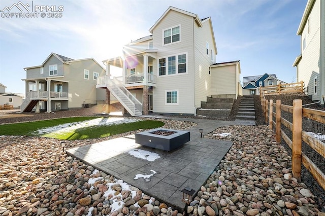 back of house featuring stairway, a patio area, a fire pit, and fence