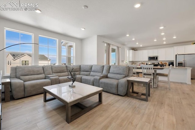 living area with light wood finished floors and recessed lighting