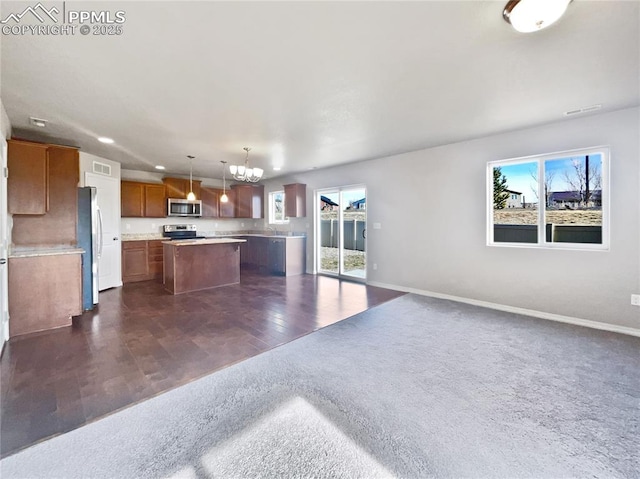 kitchen featuring appliances with stainless steel finishes, a kitchen island, dark hardwood / wood-style flooring, hanging light fixtures, and a chandelier