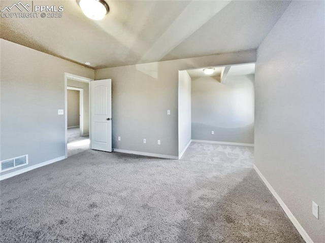 spare room with beam ceiling and carpet flooring