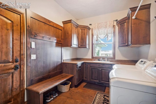 laundry area featuring cabinets, washer and clothes dryer, and sink