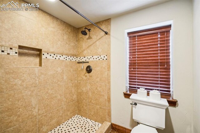 bathroom featuring toilet and a tile shower