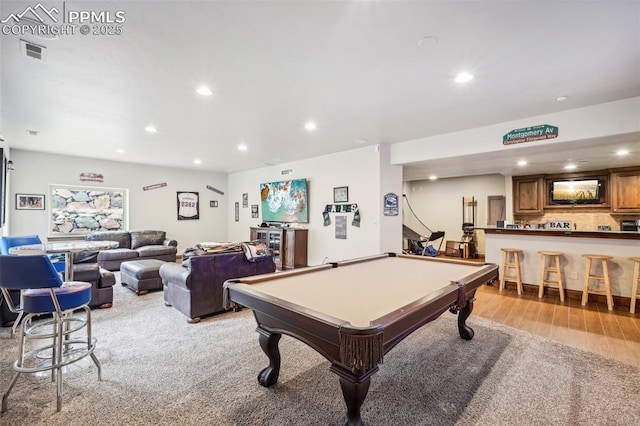 rec room featuring light hardwood / wood-style floors, pool table, and bar area