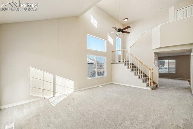 unfurnished living room with carpet, ceiling fan, and a high ceiling