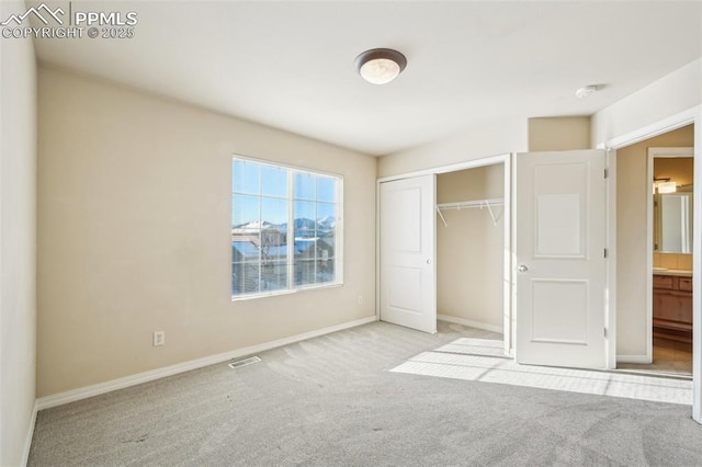 unfurnished bedroom with light carpet and a closet