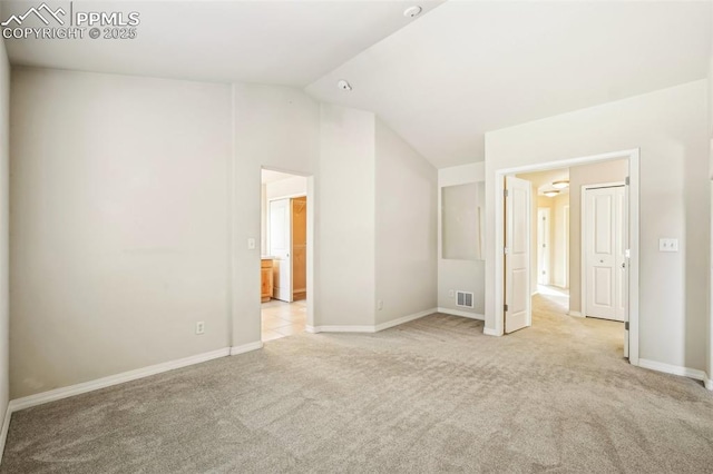 carpeted spare room featuring lofted ceiling