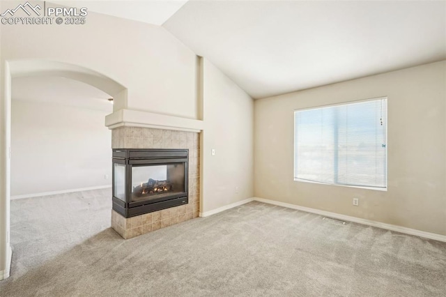 unfurnished living room featuring light colored carpet, vaulted ceiling, and a fireplace