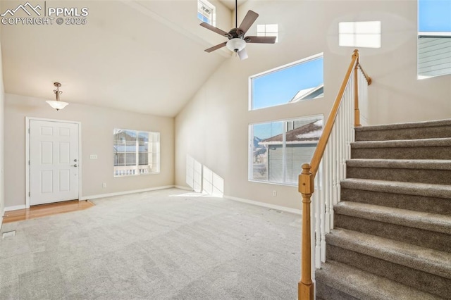 unfurnished living room featuring ceiling fan, high vaulted ceiling, and carpet flooring