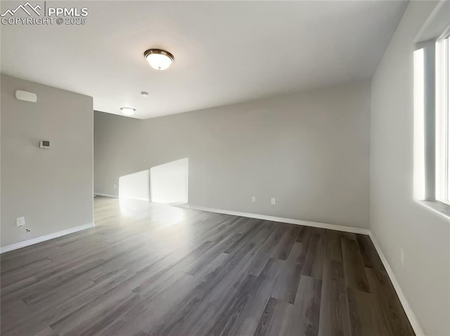 unfurnished room with dark hardwood / wood-style flooring