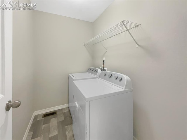 laundry area featuring hardwood / wood-style flooring and washing machine and clothes dryer