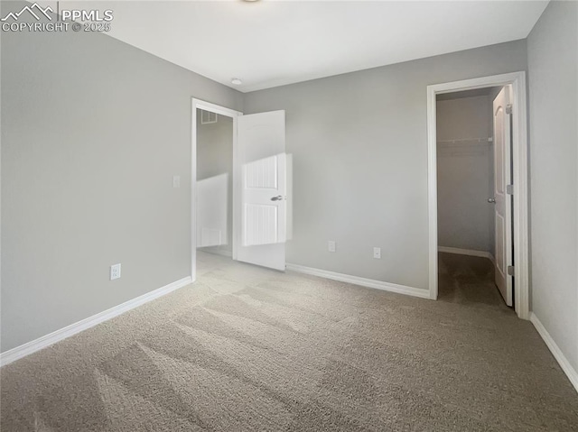 unfurnished bedroom with light carpet, a closet, and a walk in closet