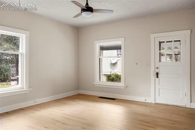 foyer entrance featuring light hardwood / wood-style floors, a textured ceiling, and ceiling fan