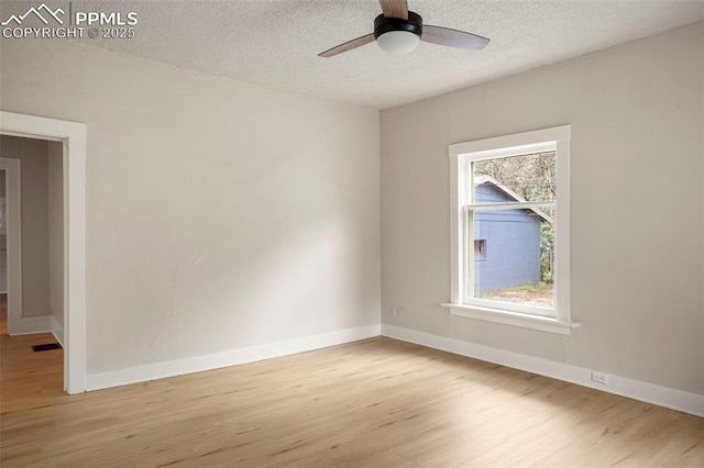 empty room featuring ceiling fan, a textured ceiling, and light hardwood / wood-style flooring