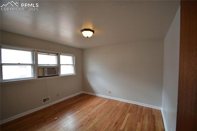 empty room with cooling unit and light hardwood / wood-style flooring