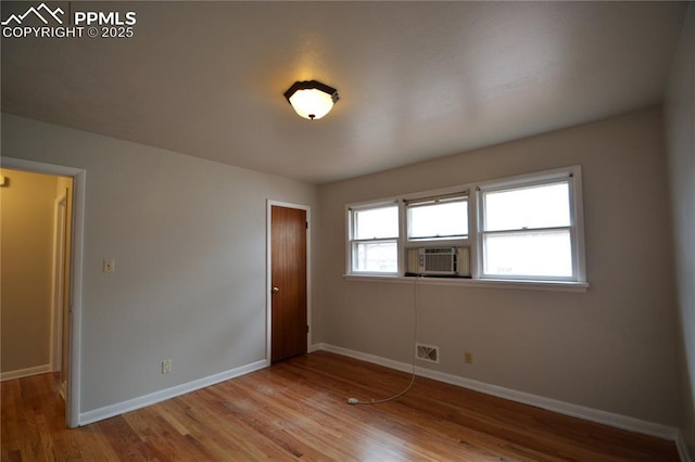 spare room with cooling unit and light hardwood / wood-style flooring