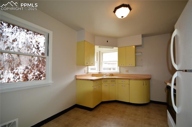 kitchen featuring wooden counters, sink, white refrigerator, and electric range