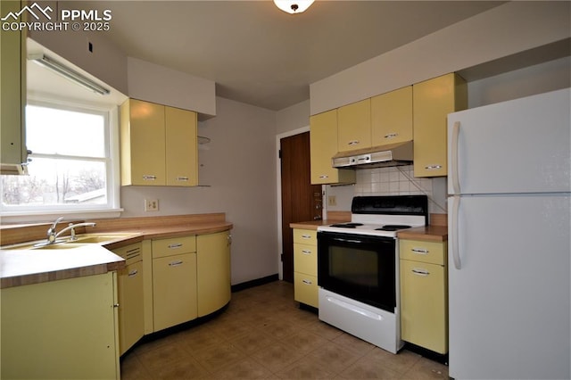 kitchen featuring white fridge, backsplash, range with electric cooktop, and sink