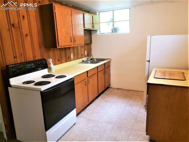 kitchen with sink, wood walls, and electric stove