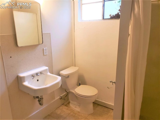 bathroom featuring toilet, tile patterned flooring, and sink