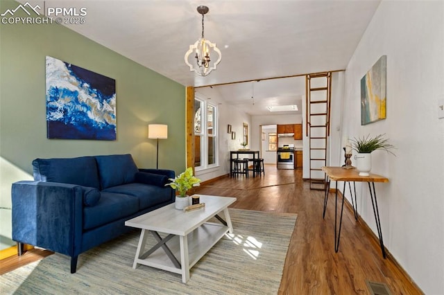 living room featuring a chandelier and wood-type flooring