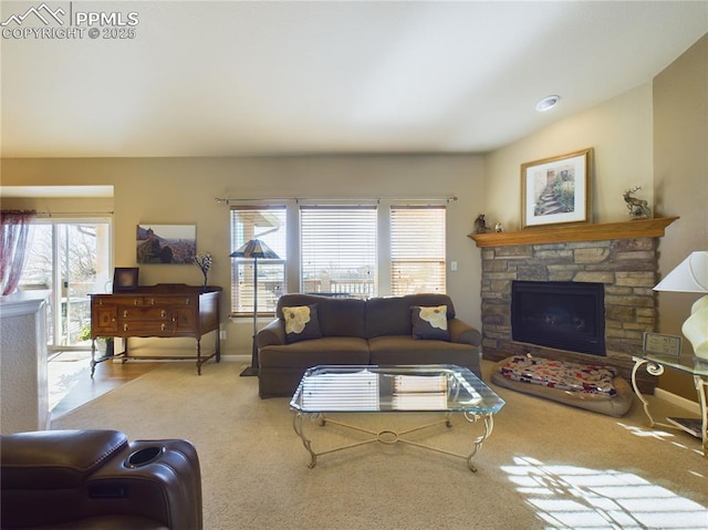 carpeted living room featuring a wealth of natural light and a stone fireplace