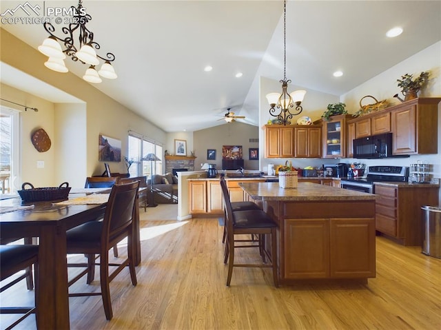 kitchen with decorative light fixtures, lofted ceiling, stainless steel electric range, ceiling fan with notable chandelier, and light hardwood / wood-style flooring