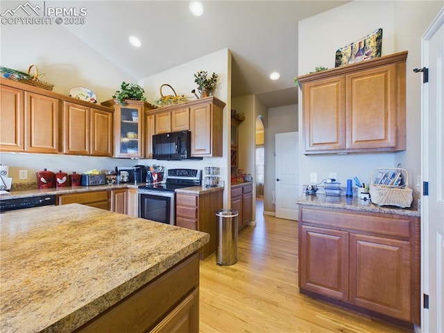 kitchen with vaulted ceiling, light hardwood / wood-style flooring, and black appliances