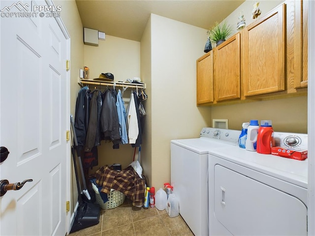 clothes washing area featuring light tile patterned flooring, separate washer and dryer, and cabinets