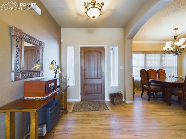 entryway with a notable chandelier and light hardwood / wood-style floors