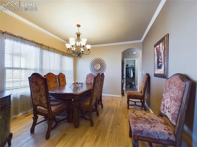 dining space featuring light hardwood / wood-style flooring, ornamental molding, and a chandelier